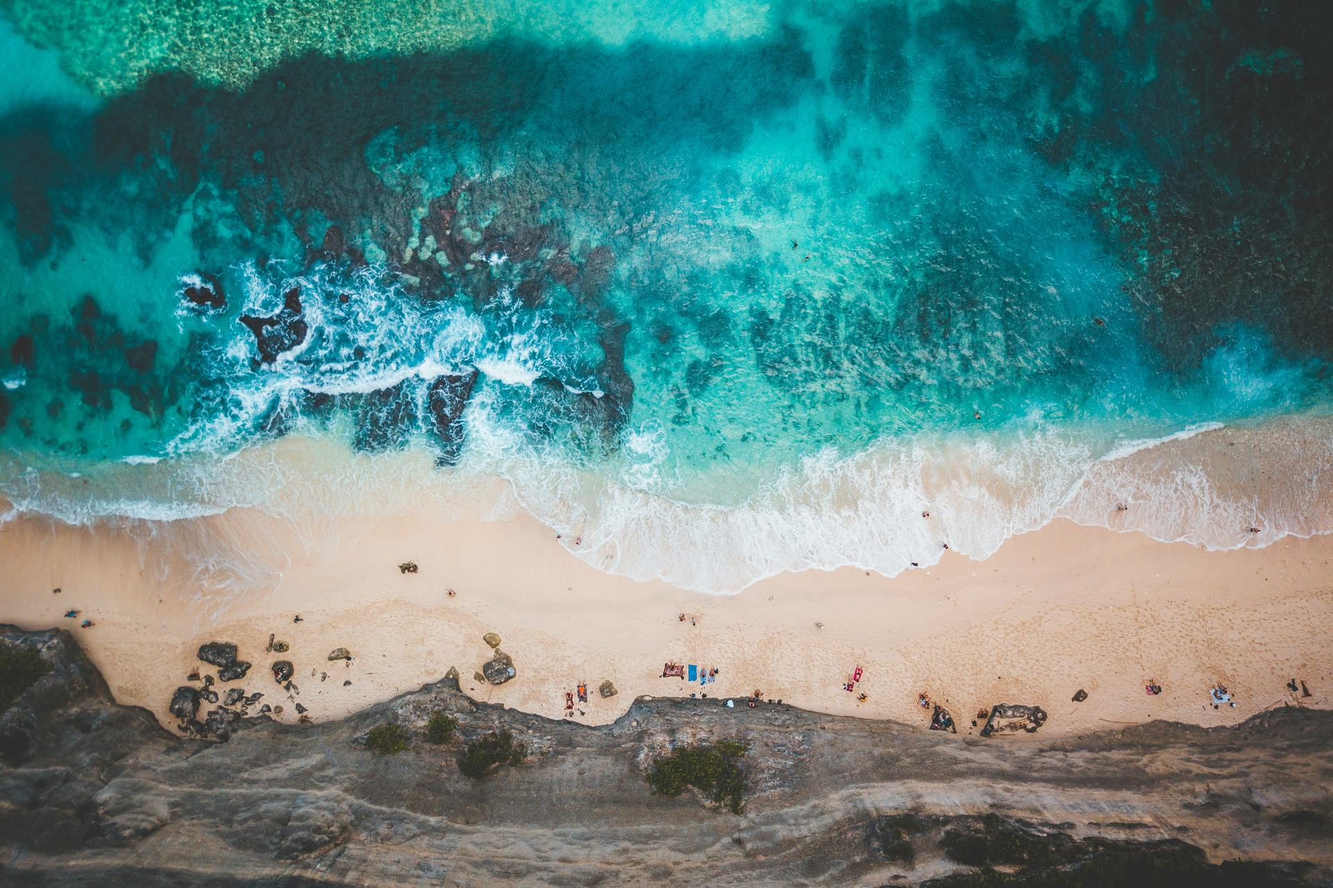 Aerial view of a cliff-flanked beach in Bali